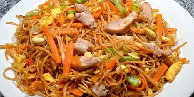 Gebratene Nudeln mit Hühnchen und Gemüse im Wok serviert