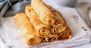 Pfannkuchen mit Vanillepudding ohne Mehl auf Teller mit Beeren und Puderzucker