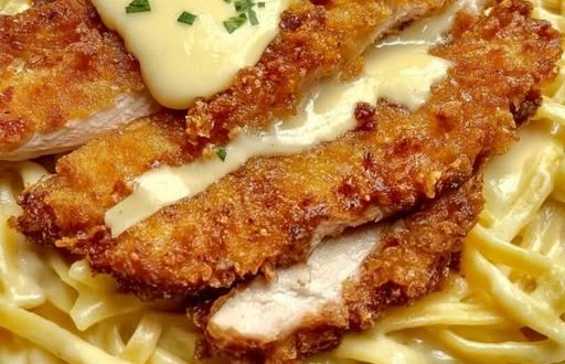 Knuspriges Hähnchen mit cremiger Pasta auf Teller angerichtet