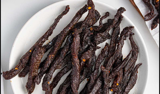 Air Fryer Beef Jerky Streifen auf einem Holzbrett serviert