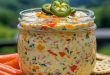 Cremiger Frischkäse-Dip mit Paprika, Jalapeño und frischen Kräutern in Schale serviert