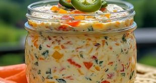 Cremiger Frischkäse-Dip mit Paprika, Jalapeño und frischen Kräutern in Schale serviert