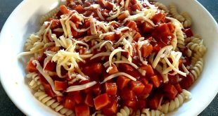 Makkaroni mit Tomatensoße und Geflügelwurst auf Teller serviert