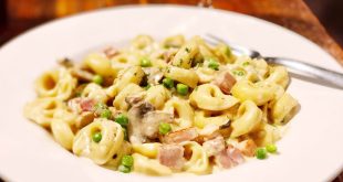 Cremige Toskanische Tortellini mit Spinat, Tomaten und Parmesan in Pfanne serviert