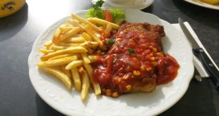 Knuspriges Zigeunerschnitzel mit Paprikasauce, Salat und Pommes