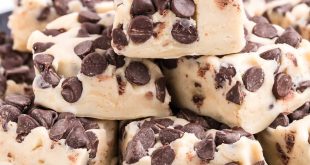 Helles Cookie-Dough-Fudge mit vielen Schokoladenstückchen in Quadrate geschnitten auf einem Servierteller.