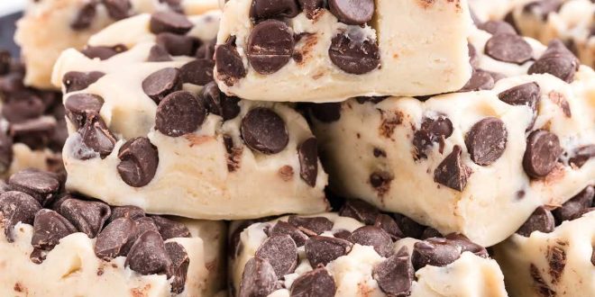 Helles Cookie-Dough-Fudge mit vielen Schokoladenstückchen in Quadrate geschnitten auf einem Servierteller.