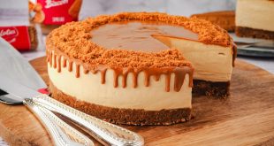 Ein cremiger Biscoff Caramel Cheesecake mit Karamell-Spiegel und Keks-Garnitur auf einer Servierplatte.